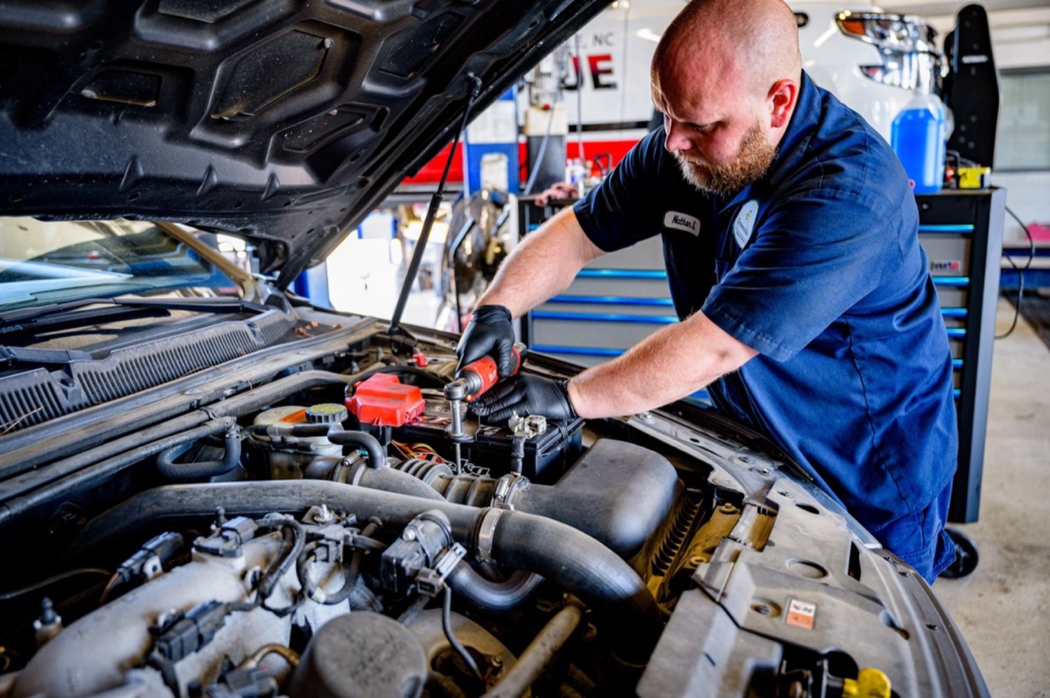 A mechanic working under the bonnet of a car